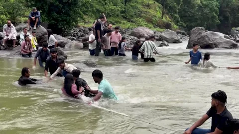 People helping each other cross a flood river holding a rope 4K video Stock-Footage 340251831