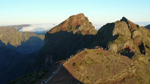 People Hike on a Mountain Peak Path at Sunrise with Scenic Landscape Stock Footage 334590499