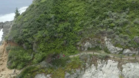 A people hiking down cliff off the coast of ocean Video stock 155463716