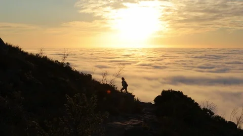 People Hiking Up A Mountain During Sunset Over A Sea OF Clouds Stock Footage