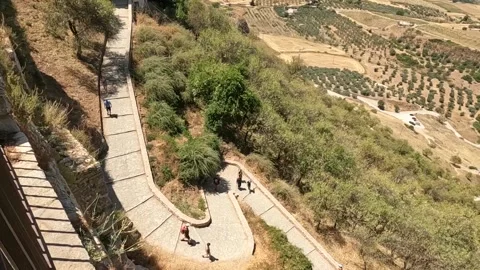 People hiking walkway path down the hill in hot, dry summer day Ronda, Spain Video stock 220728185