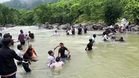 People holding a rope while crossing a fast-flowing river in a jungle 動画素材 340251834