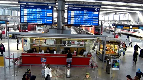 People at an information desk inside Munich central train station Stock Footage 71948029