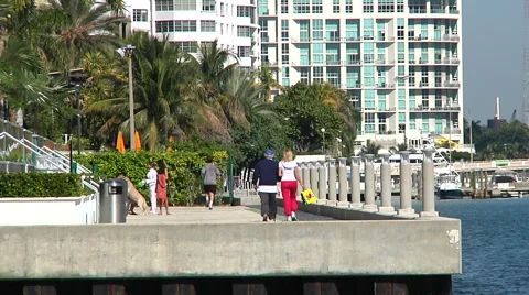 People jogging and walking on a Brickell walkway by the bay in Miami. 스톡 동영상 61242625