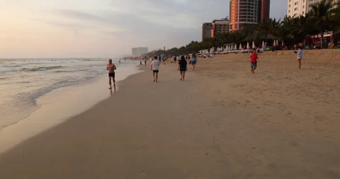 People jogging and walking on My Khe Beach at early morning, POV shot Stock Footage 345647022