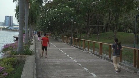 People jogging around the Benjakitti park, Bangkok Stock Footage