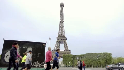 People jogging past Eiffel Tower - graffiti - joggers in Paris France in 4K 1080 Stock Footage 94003248