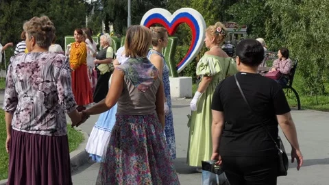 People join hands preparing to dance near the sculpture of the heart. Vídeos de archivo 249457379