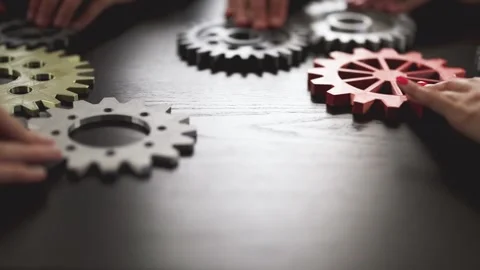People joining cog wheel on the black desk. Stock Footage 260233264