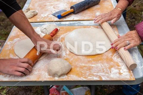 People kneading their pizza doughs as part of an outdoor bread making workshop Stock Photos