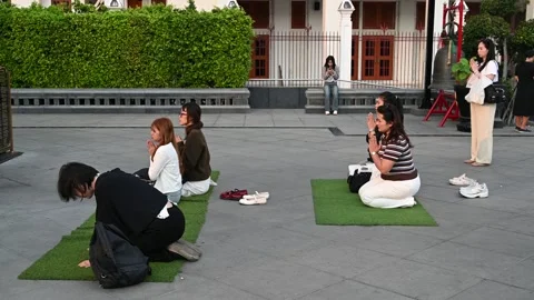 People kneel in prayer at Somdet To Memorial Video stock 338385203