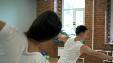 People lean to side spreading hands at yoga class in studio Stock Footage 208034812
