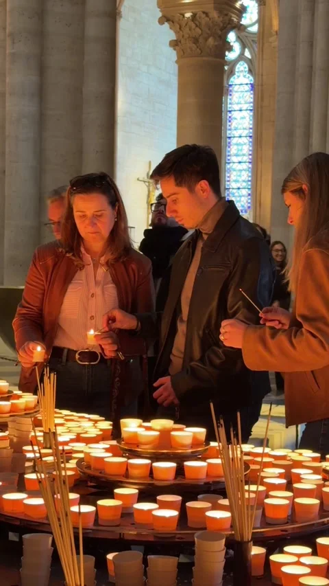 People lighting prayer candles inside Notre Dame Cathedral in Paris Stock Footage 339812808