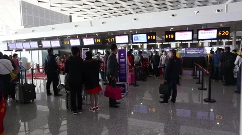 People line up a queue to check-in in the terminal 2 departure hall of Zhengzhou Stock Footage 61965511