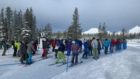 People lining up in queues to get on the ski lift to reach the mountaintop in Stock-Footage 220240337