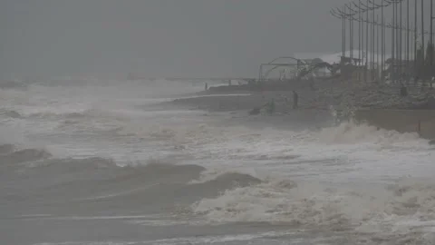 People look at big waves during a storm in Batumi Stock Footage 223389285