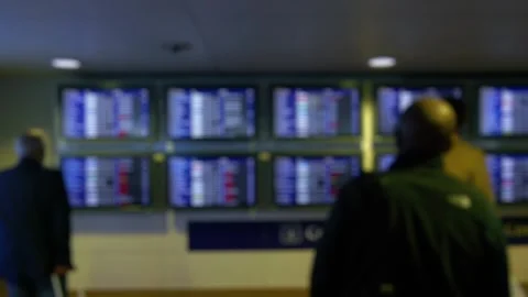 People looking at flight information display screens in an airport terminal.. Stock Footage 282472832