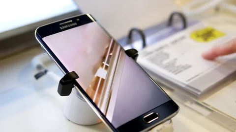 People looking price tag with display Samsung Galaxy Note 7 cellphone Stock Footage 72138124