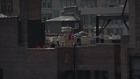 People looking at the sky from rooftop Video stock 99428533
