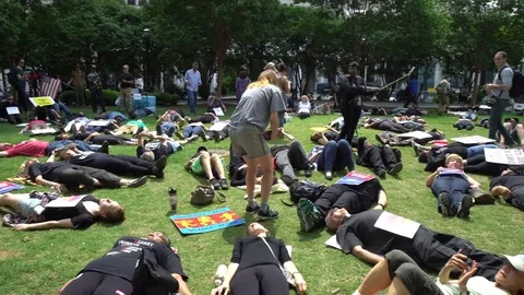 People lying down during a protest against president Trump's policies Stock Footage 76836039