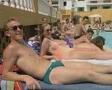 People lying on sunloungers next to pool looking at camera SD Footage