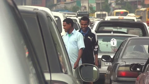 People make their way through cars stuck in a traffic jam Stock Footage 74170458