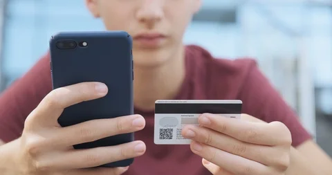 People makes online purchases using a credit card and mobile phone, outdoors. 스톡 동영상 112499073