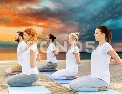 People making yoga in hero pose outdoors Stock Photos