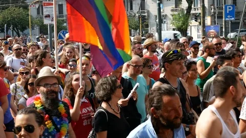 People march holding rainbow flags at Milano pride parade. 動画素材 79637391