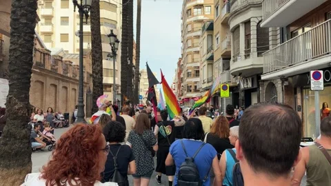 People marching with rainbow flags during Cullera Gay Pride parade Stock Footage 337784065