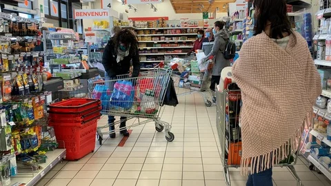 People with mask and gloves wait at the supermarket checkout Stock Footage
