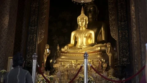 People meditating inside a temple  in front of a Buddha statue Stock Footage 75538523