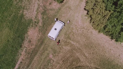 People move away from a white van on dirt road and enter the woods Stock Footage 78085495
