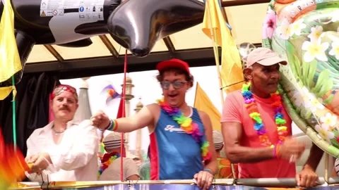 People on moving float Celebrating in Brighton Pride Parade waving Rainbow Flags Stock Footage 281335639