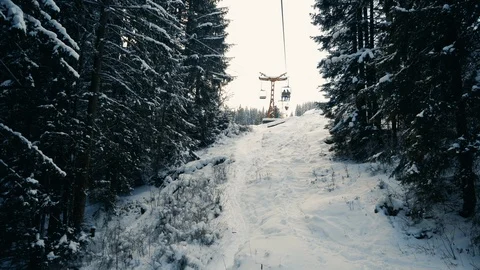 People moving up the snow forest on ski elevator Stock Footage 120052327