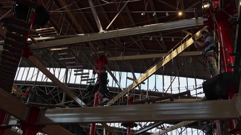 People navigate obstacles on an indoor adventure park course. Stock Footage 339246606