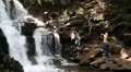 People near beautiful waterfall in Carpathian Mountains, Ukraine HD Footage