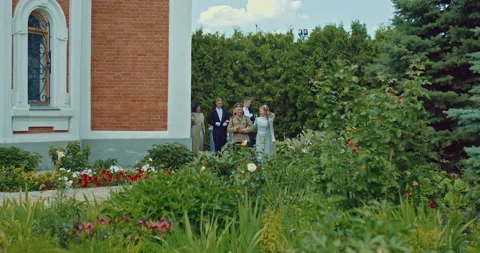 People of the nobility are walking through the beautiful garden of the mansion Stock Footage 226862390
