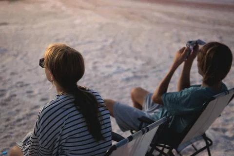 People observing a celestial event using solar eclipse glasses and a smartp.. Stock Photos