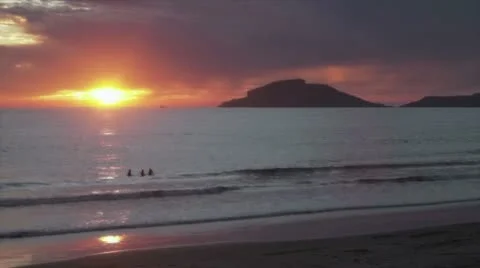 People in ocean by sunset Stock Footage 10785637