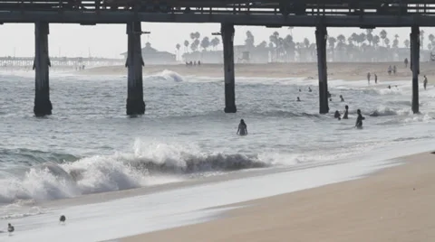 People in Ocean Under Pier at Sunset Stock Footage 30461332