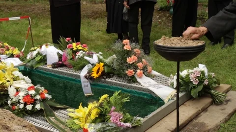 People at an open grave throwing sand Stock Footage 102444195