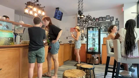 People ordering drinks and socializing in a small eclectic cafe in New York City 스톡 동영상 312020669
