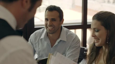 People ordering food and drink to waiter in restaurant Stock Footage
