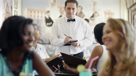 People ordering meal to waiter in restaurant Stock Footage