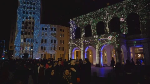 People pass by 3D video mapping projections on buildings during Spotlight Vídeos de archivo 106693453