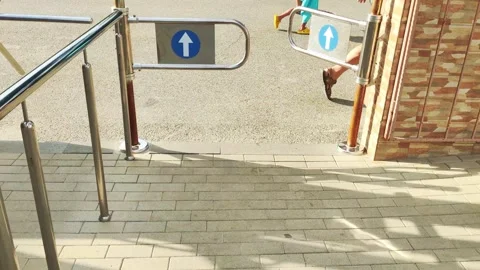 People pass through the turnstile into a closed area, close-up Stockbeeldmateriaal 295603439