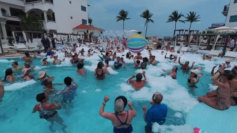 People passing a beach ball at a resort pool party in Mexico Stock Footage 337221659