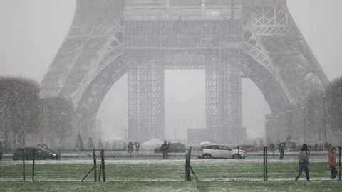 People passing by the Eiffel tower in Paris on a day with heavy snow Stock Footage 290052064