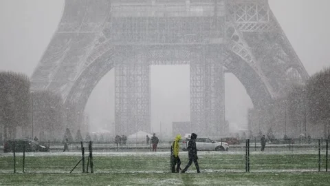 People passing by the Eiffel tower in Paris on a day with heavy snow Stock Footage 290052664